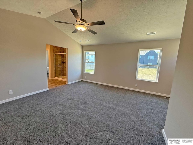 carpeted spare room with a textured ceiling, ceiling fan, and lofted ceiling