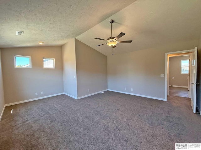 carpeted empty room featuring ceiling fan, lofted ceiling, and a textured ceiling