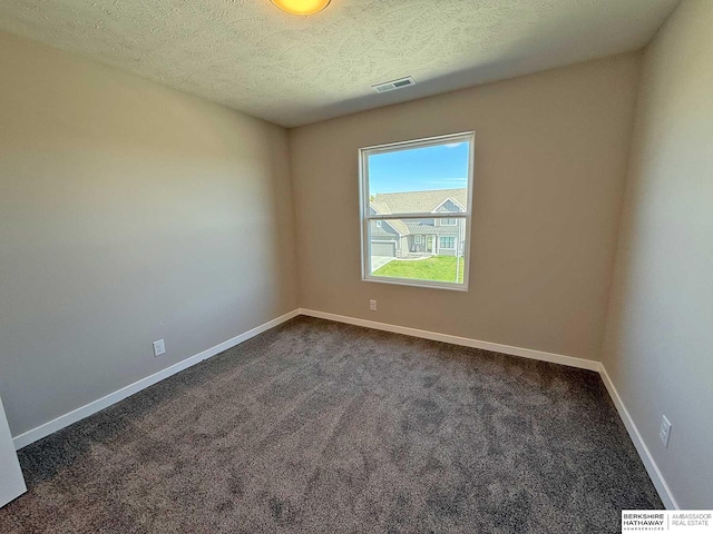 carpeted spare room with a textured ceiling