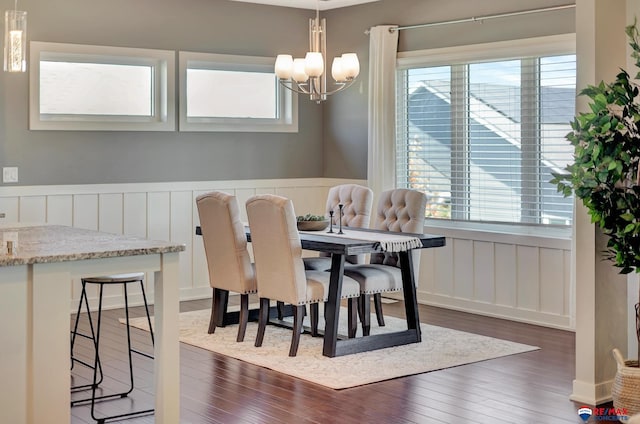 dining area featuring dark hardwood / wood-style flooring and an inviting chandelier