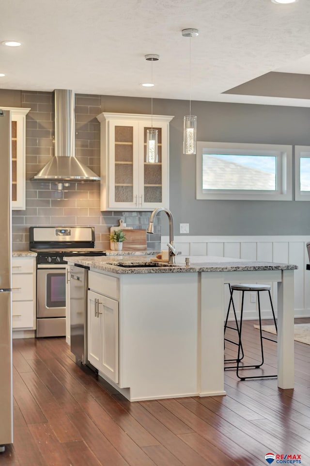 kitchen featuring light stone countertops, sink, wall chimney range hood, dark hardwood / wood-style flooring, and white cabinets