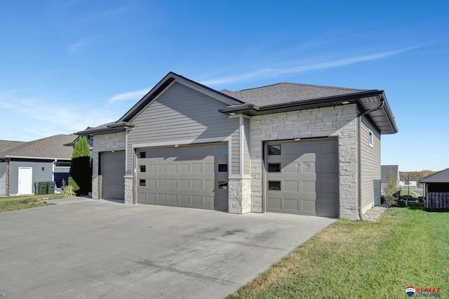 exterior space featuring a front yard, a garage, and central air condition unit