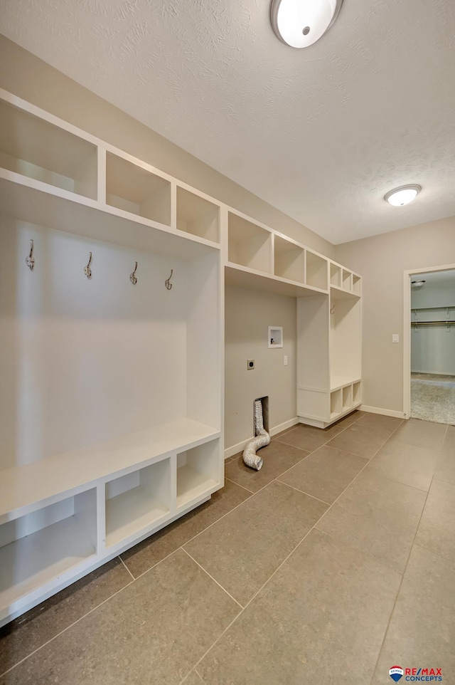 mudroom featuring tile patterned flooring and a textured ceiling