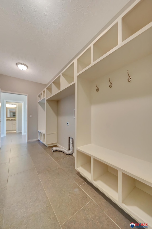 mudroom with tile patterned flooring and a textured ceiling