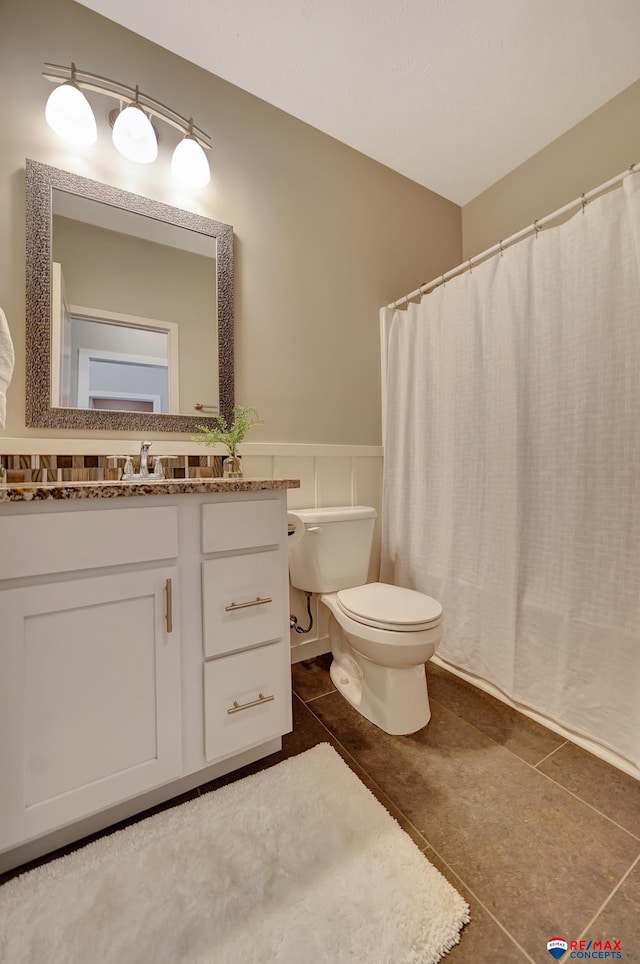 bathroom featuring tile patterned flooring, vanity, and toilet