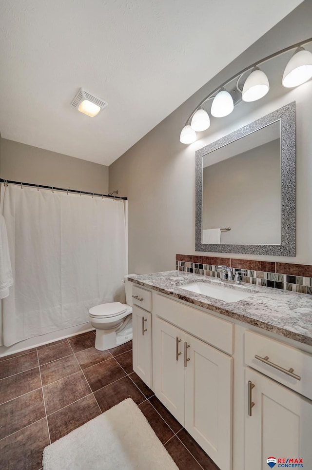 bathroom featuring backsplash, vanity, and toilet