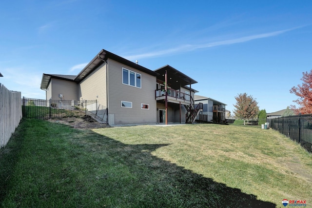 back of property featuring a wooden deck and a yard