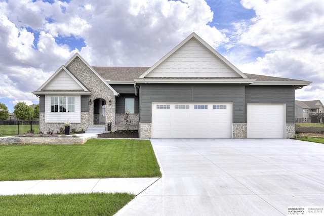 craftsman house with a front lawn and a garage