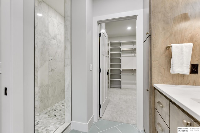 bathroom with tile patterned floors, vanity, and walk in shower