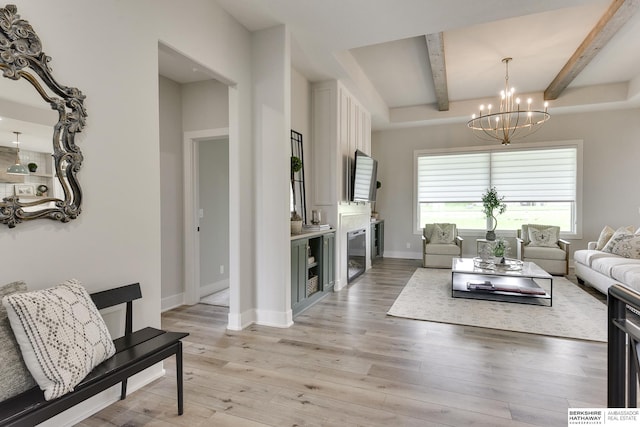 living room featuring beam ceiling, an inviting chandelier, and light wood-type flooring