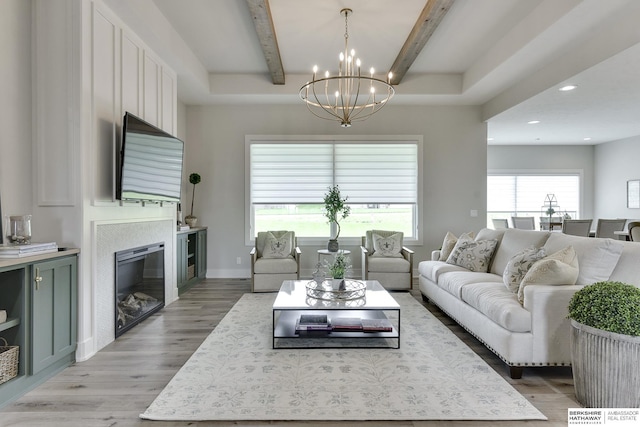 living room with a chandelier, beam ceiling, and light hardwood / wood-style floors