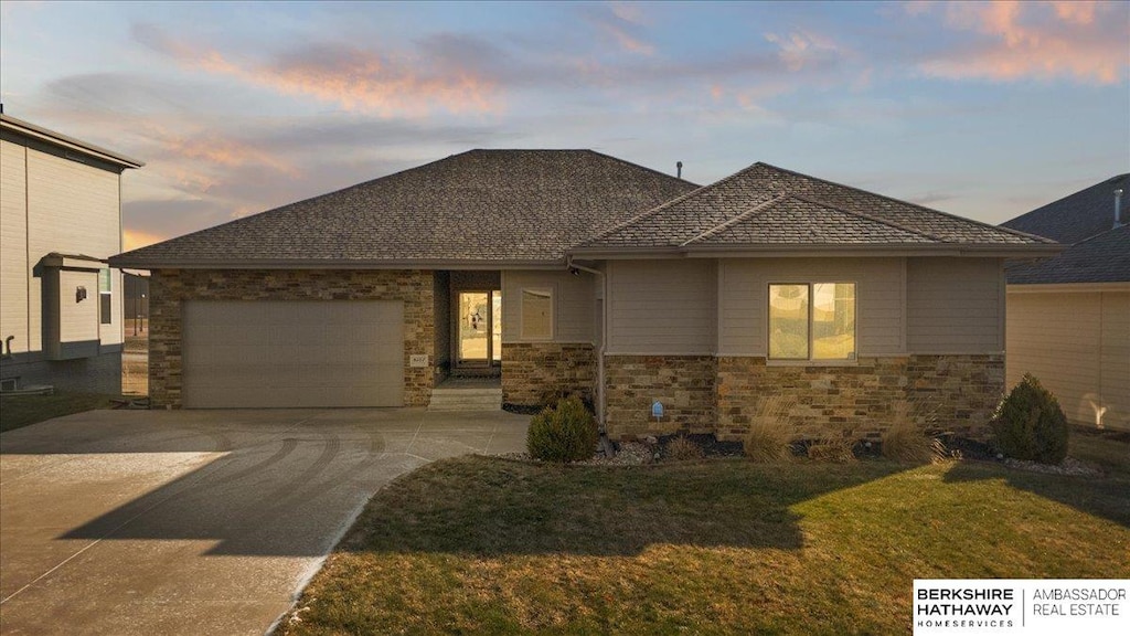 prairie-style house featuring a lawn and a garage