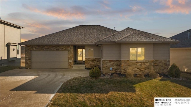 prairie-style house featuring a lawn and a garage