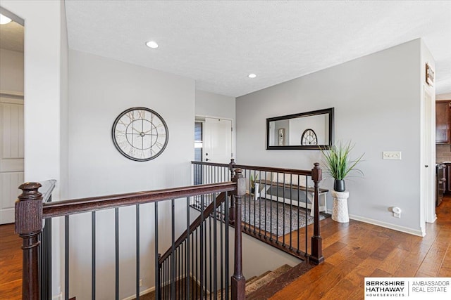 hallway featuring a textured ceiling and hardwood / wood-style flooring