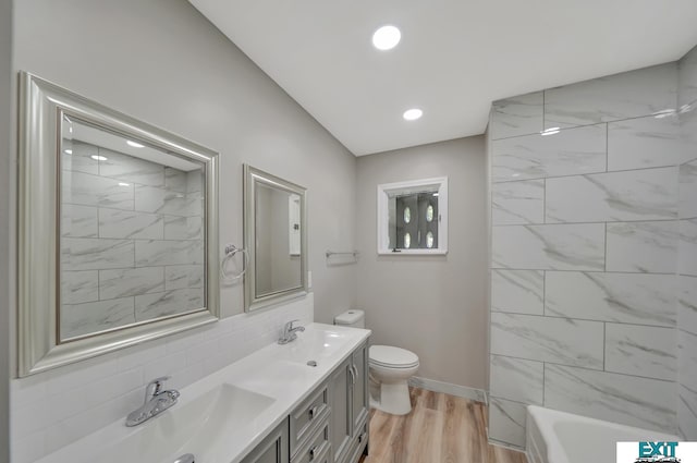 bathroom featuring decorative backsplash, hardwood / wood-style floors, vanity, and toilet