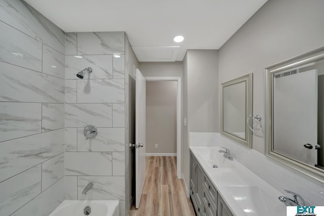 bathroom with vanity, tiled shower / bath combo, and hardwood / wood-style flooring