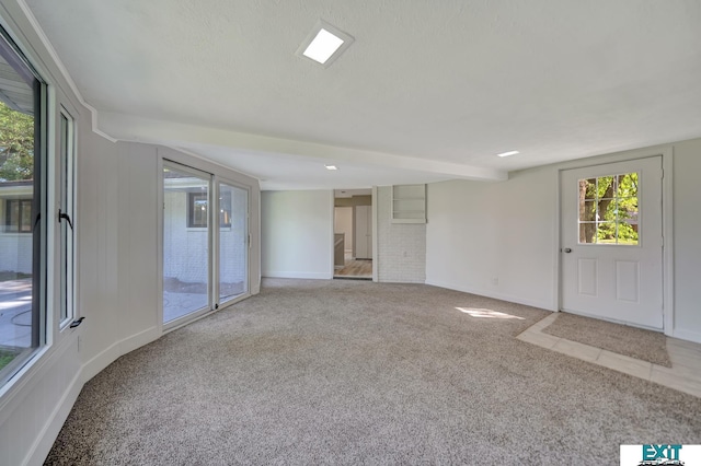 spare room with a textured ceiling and light carpet