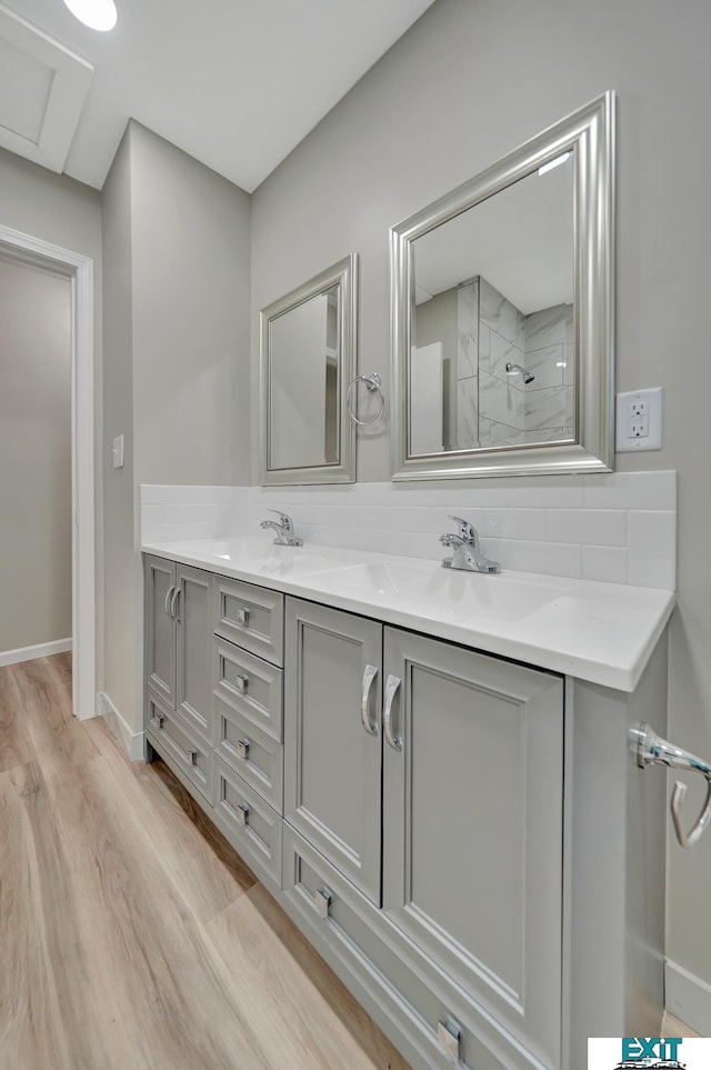 bathroom featuring tiled shower, vanity, and hardwood / wood-style flooring