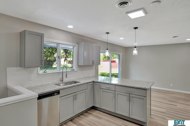 kitchen featuring light stone countertops, dishwasher, sink, gray cabinets, and light wood-type flooring