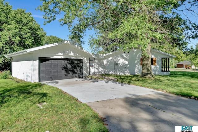 ranch-style house with a garage and a front lawn