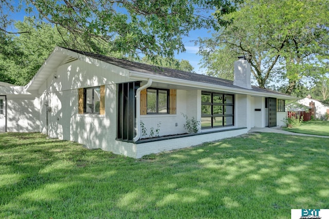 rear view of property with a lawn