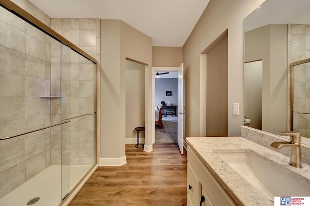 bathroom with ceiling fan, hardwood / wood-style floors, vanity, and a shower with shower door