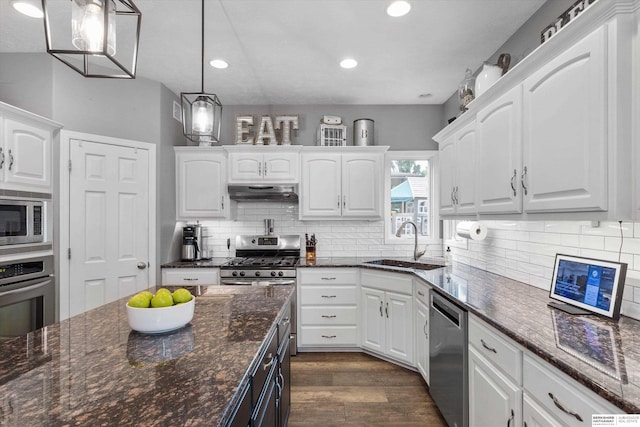 kitchen with hanging light fixtures, white cabinets, and stainless steel appliances