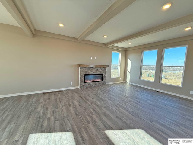 unfurnished living room with beam ceiling, wood-type flooring, and a fireplace