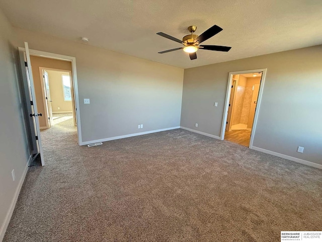 unfurnished bedroom featuring connected bathroom, ceiling fan, carpet, and a textured ceiling