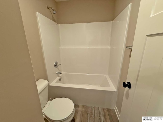 bathroom featuring shower / bathing tub combination, toilet, and wood-type flooring