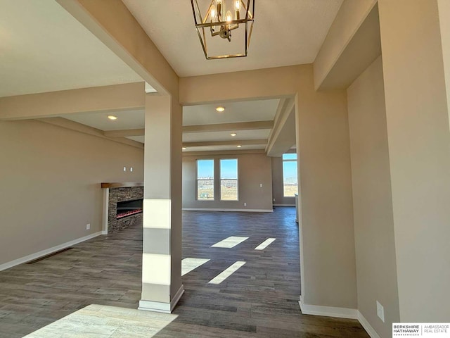 foyer entrance with dark hardwood / wood-style flooring, beam ceiling, and a stone fireplace