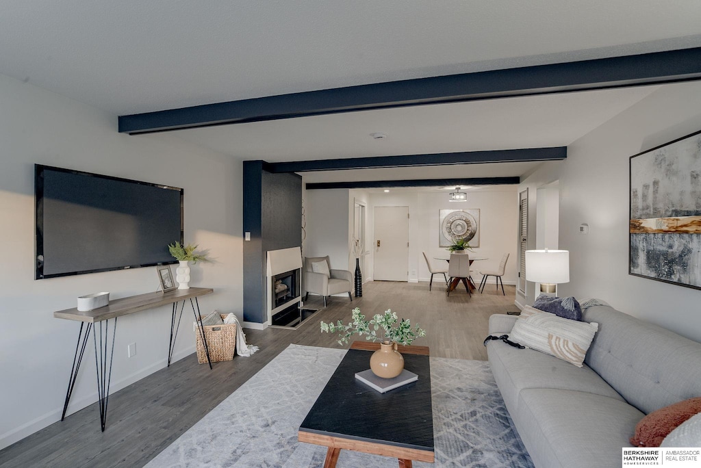 living room featuring beamed ceiling and dark wood-type flooring