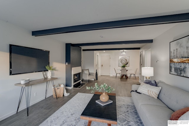 living room featuring beamed ceiling and dark wood-type flooring