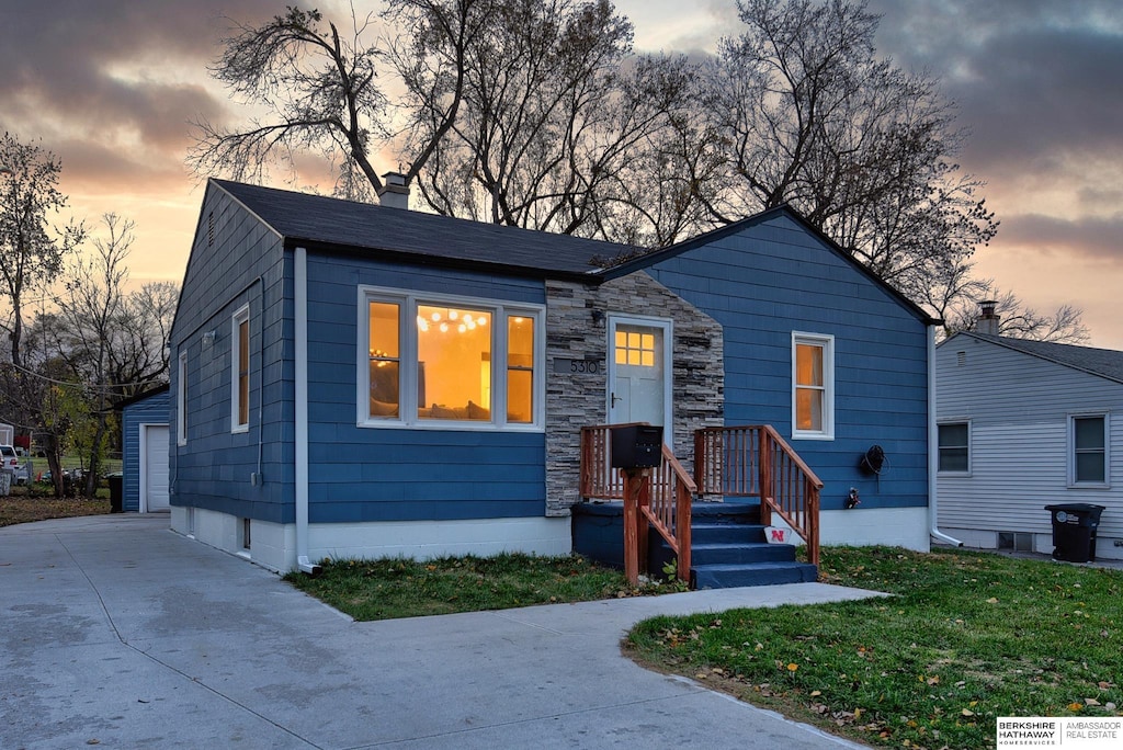 view of front of home with a yard, an outdoor structure, and a garage