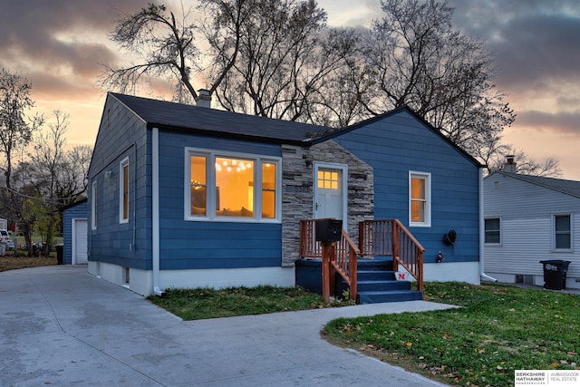 view of front of home with a yard, an outdoor structure, and a garage