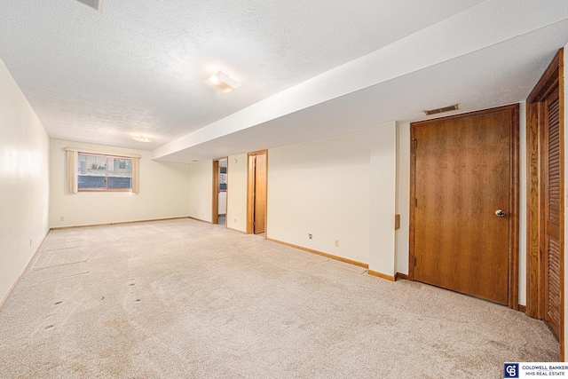 basement with a textured ceiling and light carpet