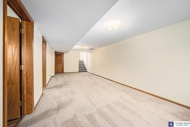 interior space with light carpet and a textured ceiling