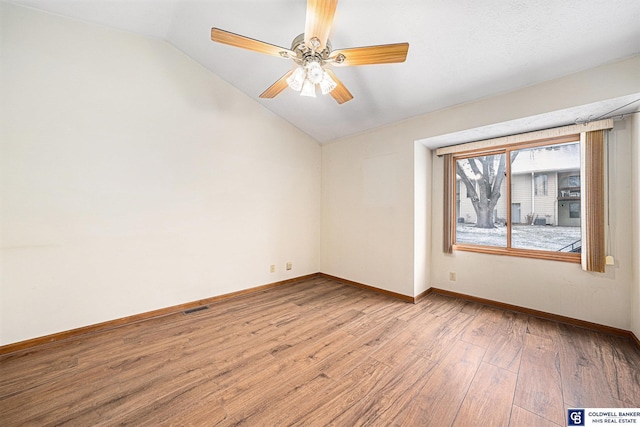 empty room with ceiling fan, light hardwood / wood-style floors, and lofted ceiling