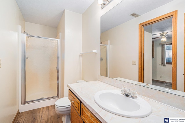 bathroom featuring hardwood / wood-style floors, vanity, toilet, a textured ceiling, and an enclosed shower