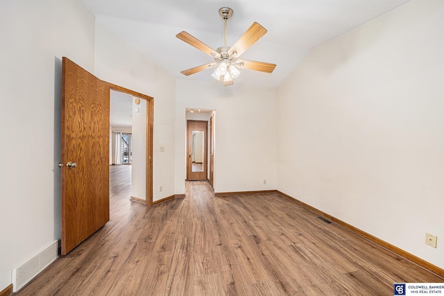 spare room with ceiling fan, wood-type flooring, and vaulted ceiling