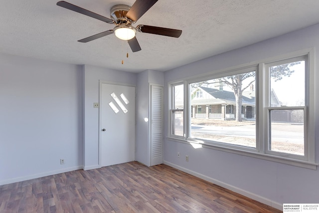 entrance foyer featuring a textured ceiling, dark hardwood / wood-style flooring, and ceiling fan