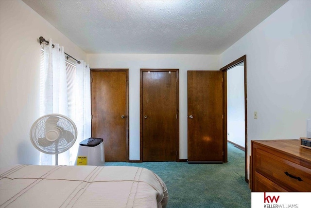 bedroom with multiple closets, carpet, and a textured ceiling