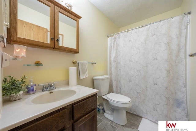 bathroom featuring vanity, toilet, and a textured ceiling