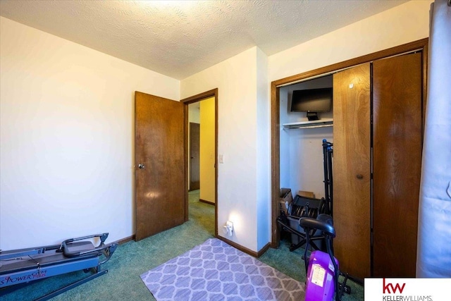 carpeted bedroom with a closet and a textured ceiling