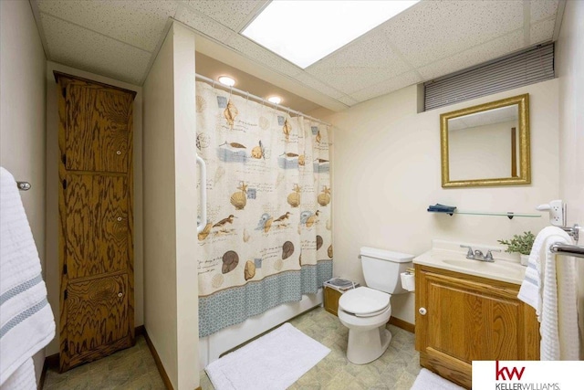 bathroom featuring vanity, a paneled ceiling, toilet, and curtained shower