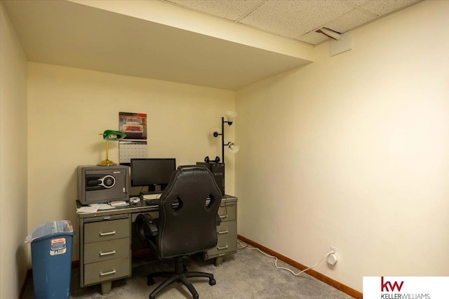 carpeted office with a paneled ceiling