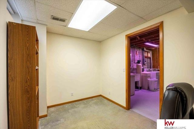 interior space featuring light carpet, washer / dryer, and a paneled ceiling