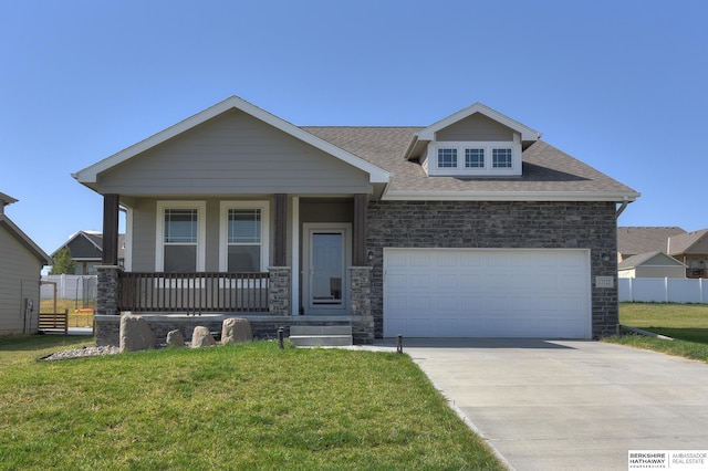 craftsman house with a garage, covered porch, and a front lawn