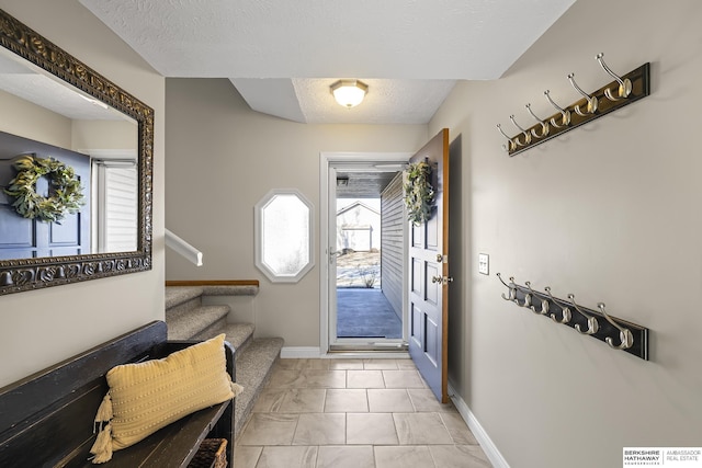 doorway featuring a textured ceiling and light tile patterned floors