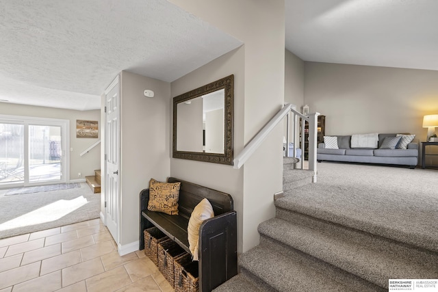 stairway with tile patterned floors and a textured ceiling